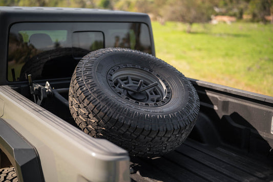 DV8 adjustable in-bed spare tire carrier installed in Jeep Gladiator JT