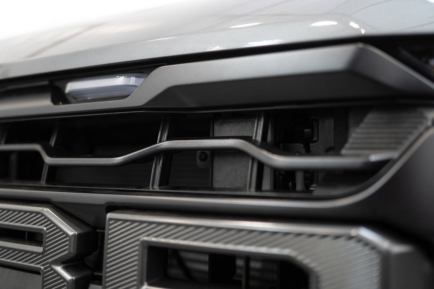 ADD AC1305101NA adaptive cruise control relocation bracket installed behind grille on 2024-2026 Ford F-150 Raptor