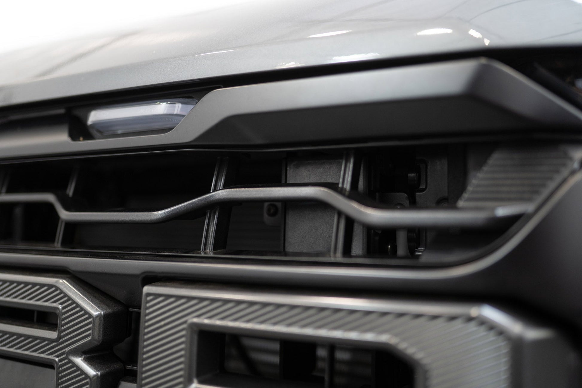 ADD AC1305101NA adaptive cruise control relocation bracket installed behind grille on 2024-2026 Ford F-150 Raptor