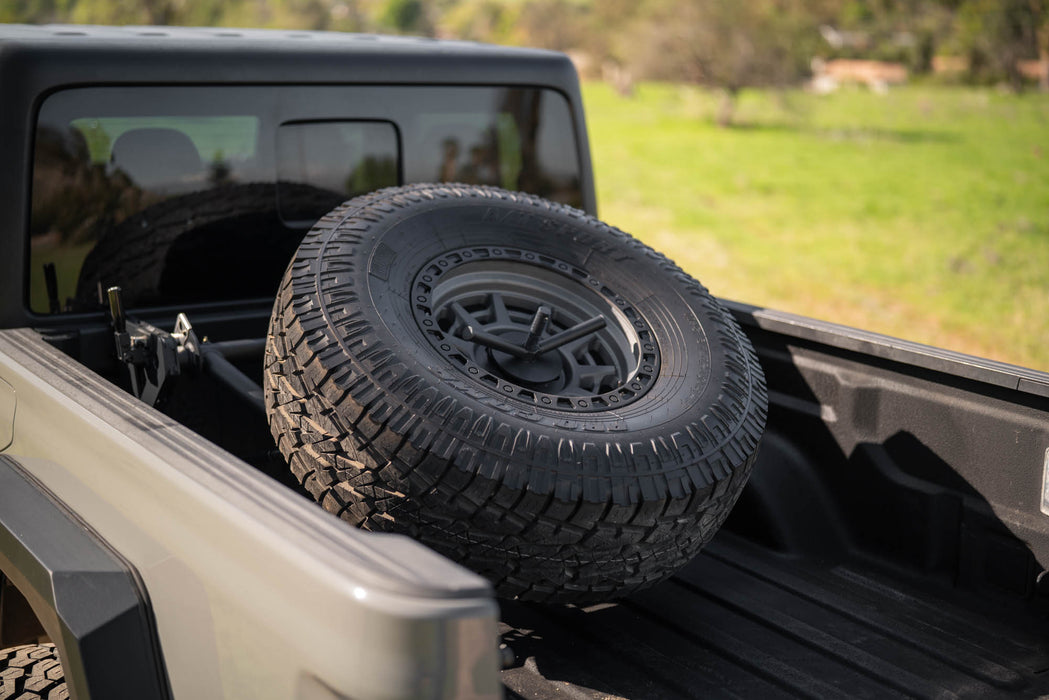 DV8 adjustable in-bed spare tire carrier installed in Jeep Gladiator JT